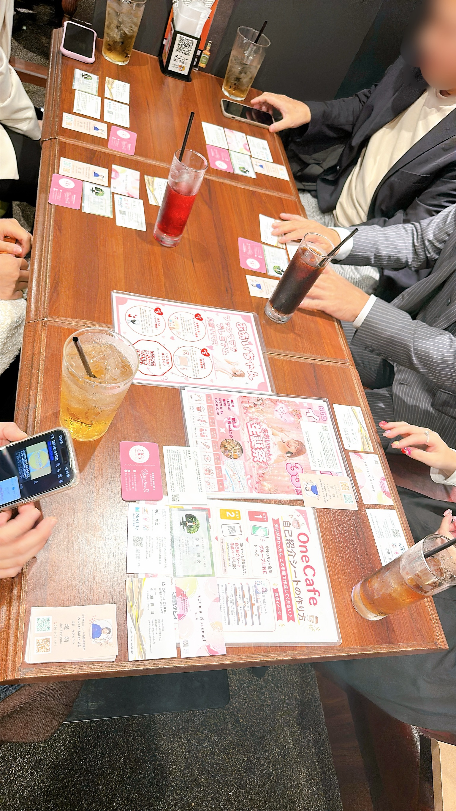 参加者が持ち寄った名刺をテーブルに広げて交流している様子